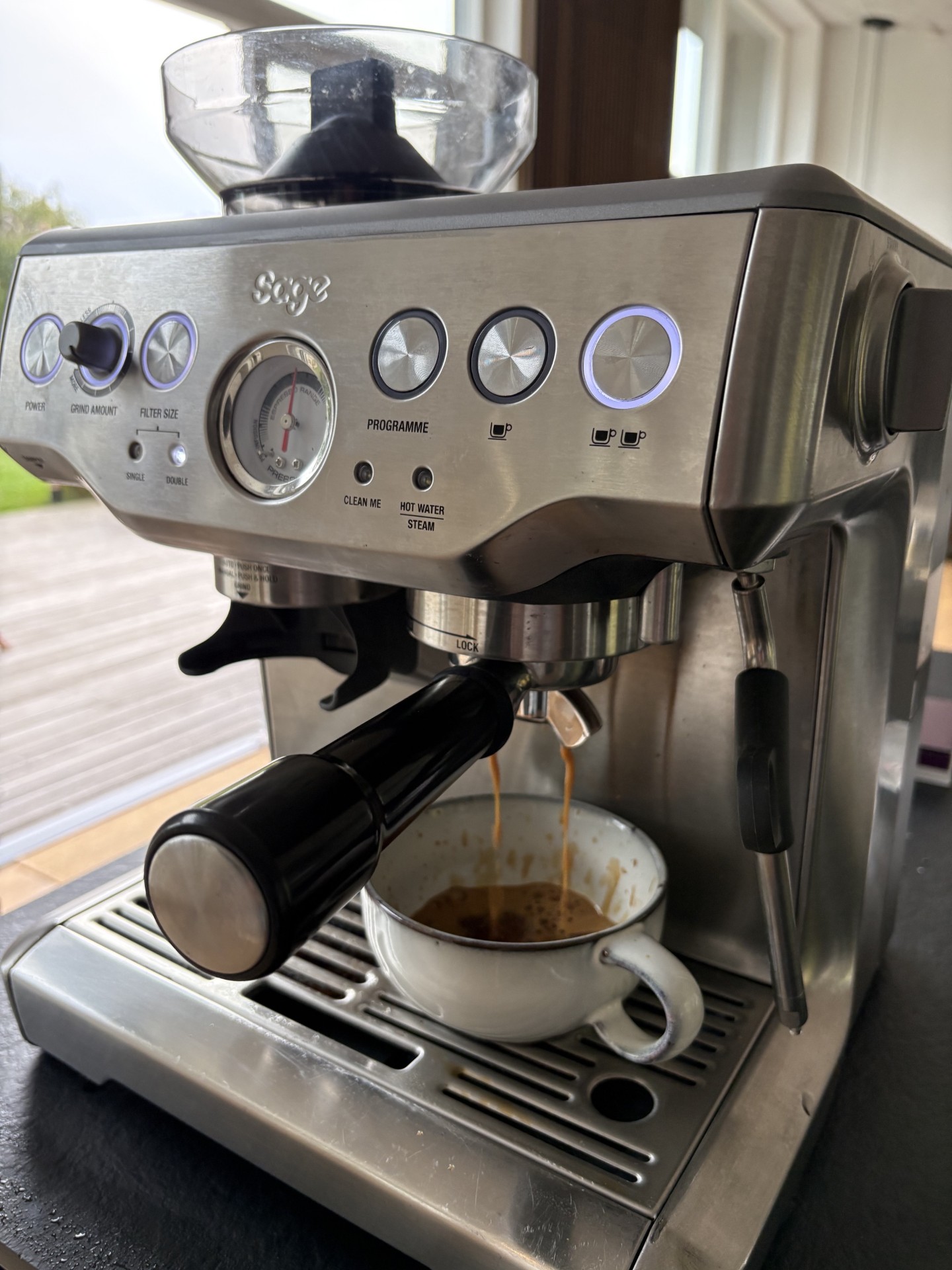 Sage Barista Express der brygger espresso i en hvid kop